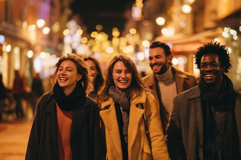 A group of diverse friends walking together on a lively city street at night with festive lights, symbolizing Libra’s love for harmony, connection, and social energy.