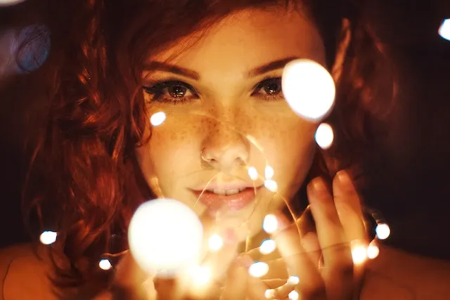 Woman surrounded by glowing lights representing Cancer's intuitive, compassionate, and emotionally sensitive personality under the influence of the Moon.