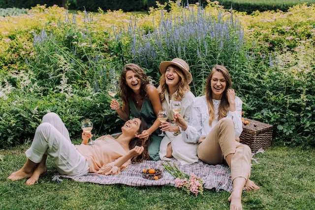 Group of friends laughing together outdoors, reflecting the adventurous, optimistic, and sociable friendships of Sagittarius.