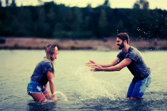 Virgo and Capricorn enjoying a playful moment by the lake, representing a relationship built on trust, stability, and shared life goals.